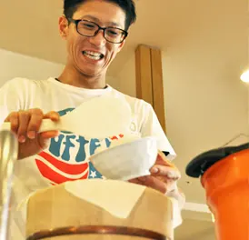 お櫃から茶碗にご飯をよそう職員