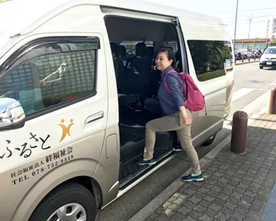 垂水駅付近で送迎シャトルバスに乗るスタッフの写真